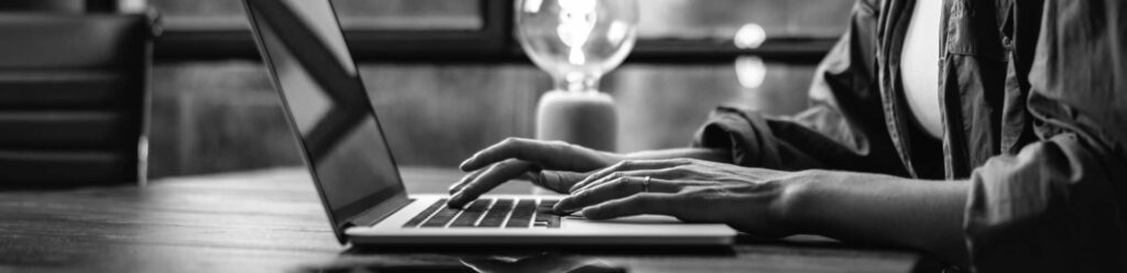 Background image of persons hands using computer