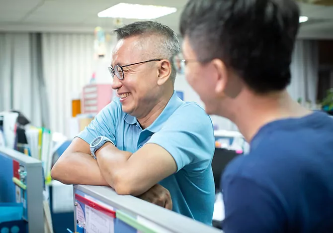 Two males chatting in workplace setting